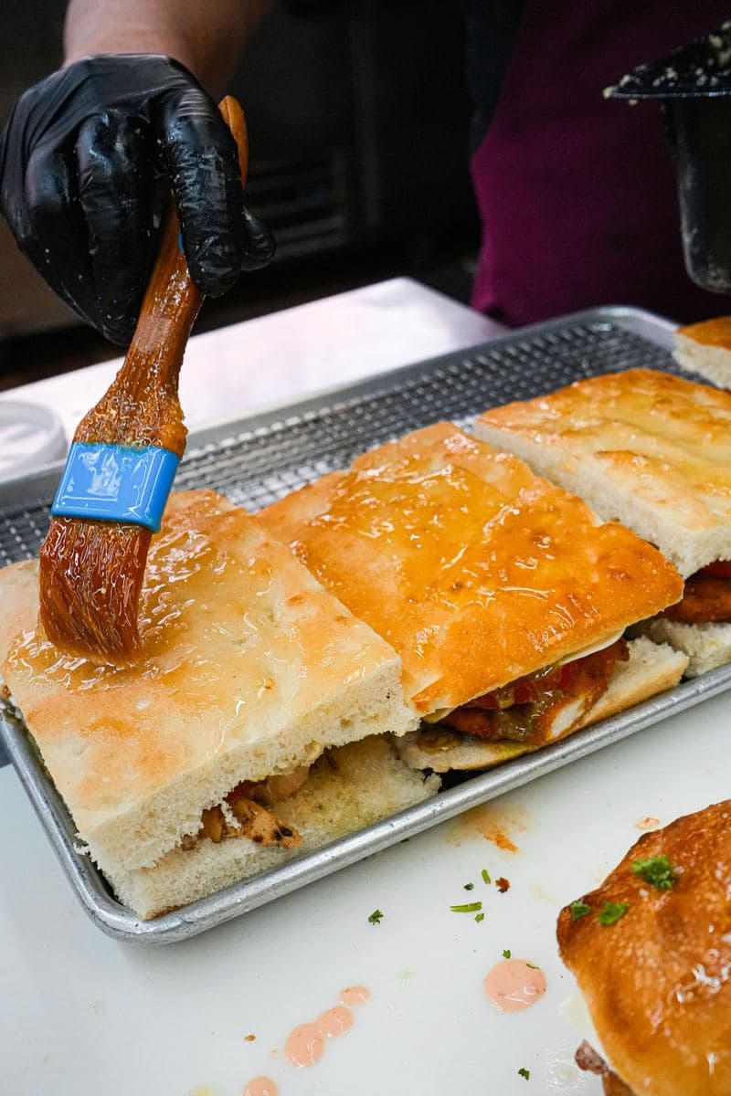 Garlic butter brushed over a tray of focaccia heroes