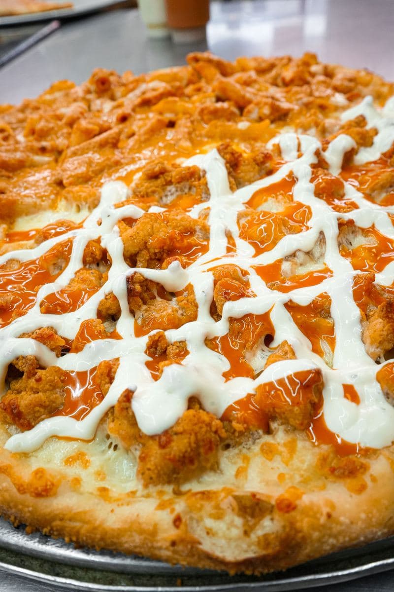 Close-up of buffalo chicken and ranch drizzle on a Bonilla's pie