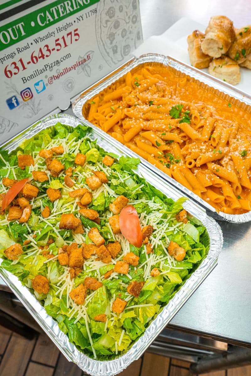Catering tray of Caesar salad with croutons, parmesan and tomato