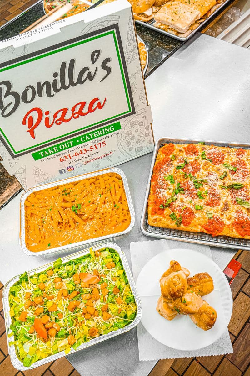 Catering spread: penne alla vodka, Caesar salad and a margherita Sicilian tray