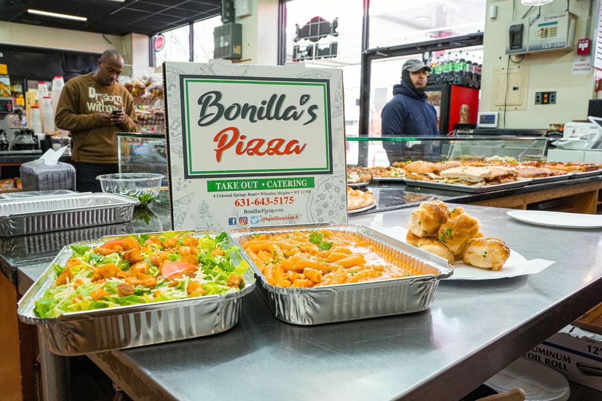 Catering trays of Caesar salad and penne alla vodka with garlic knots