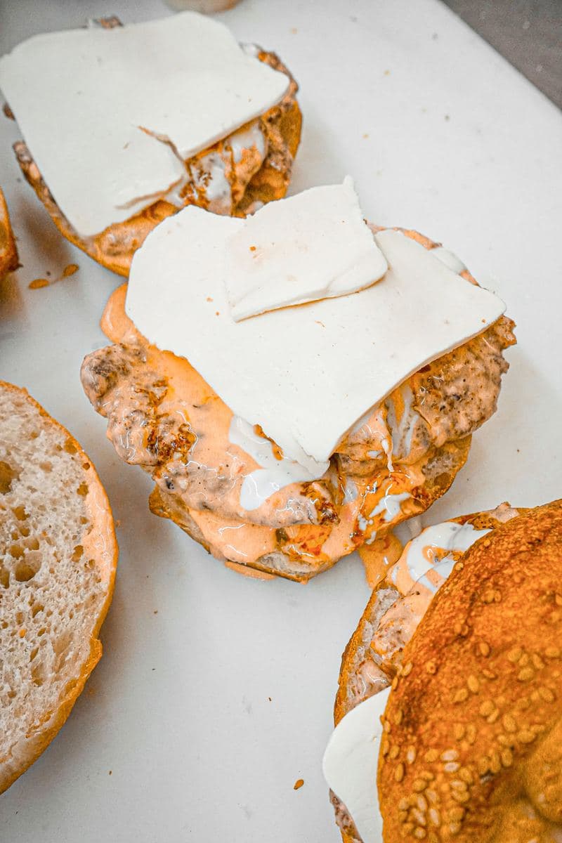 Close-up of a chicken cutlet sandwich with melted cheese and house sauce