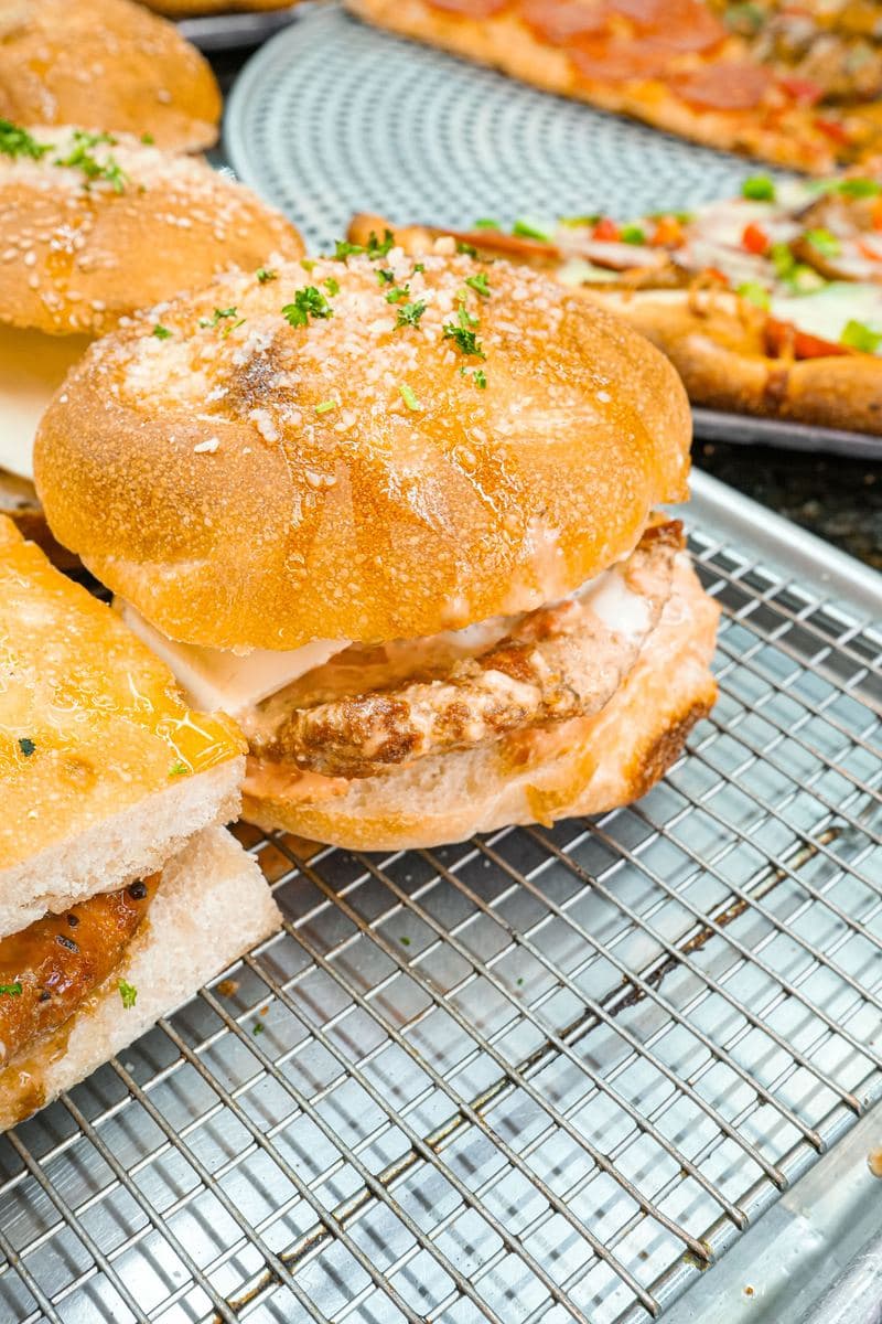 Chicken cutlet sandwich on a sesame roll cooling on a rack