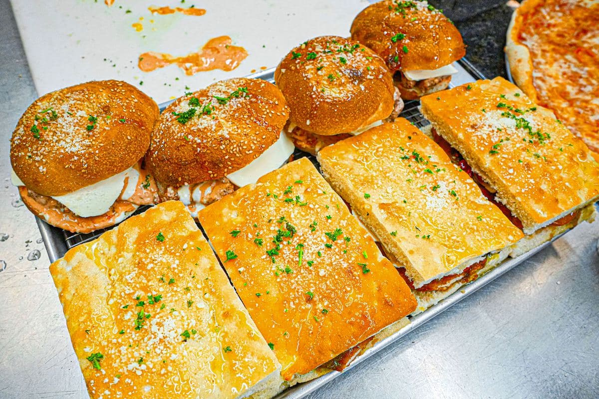 Tray of focaccia heroes and sesame rolls finished with parmesan and parsley