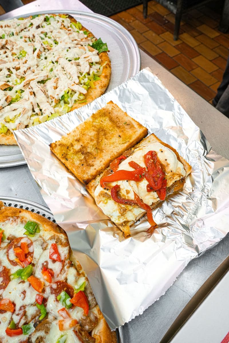 Garlic bread and roasted pepper focaccia wrapped in foil for takeout