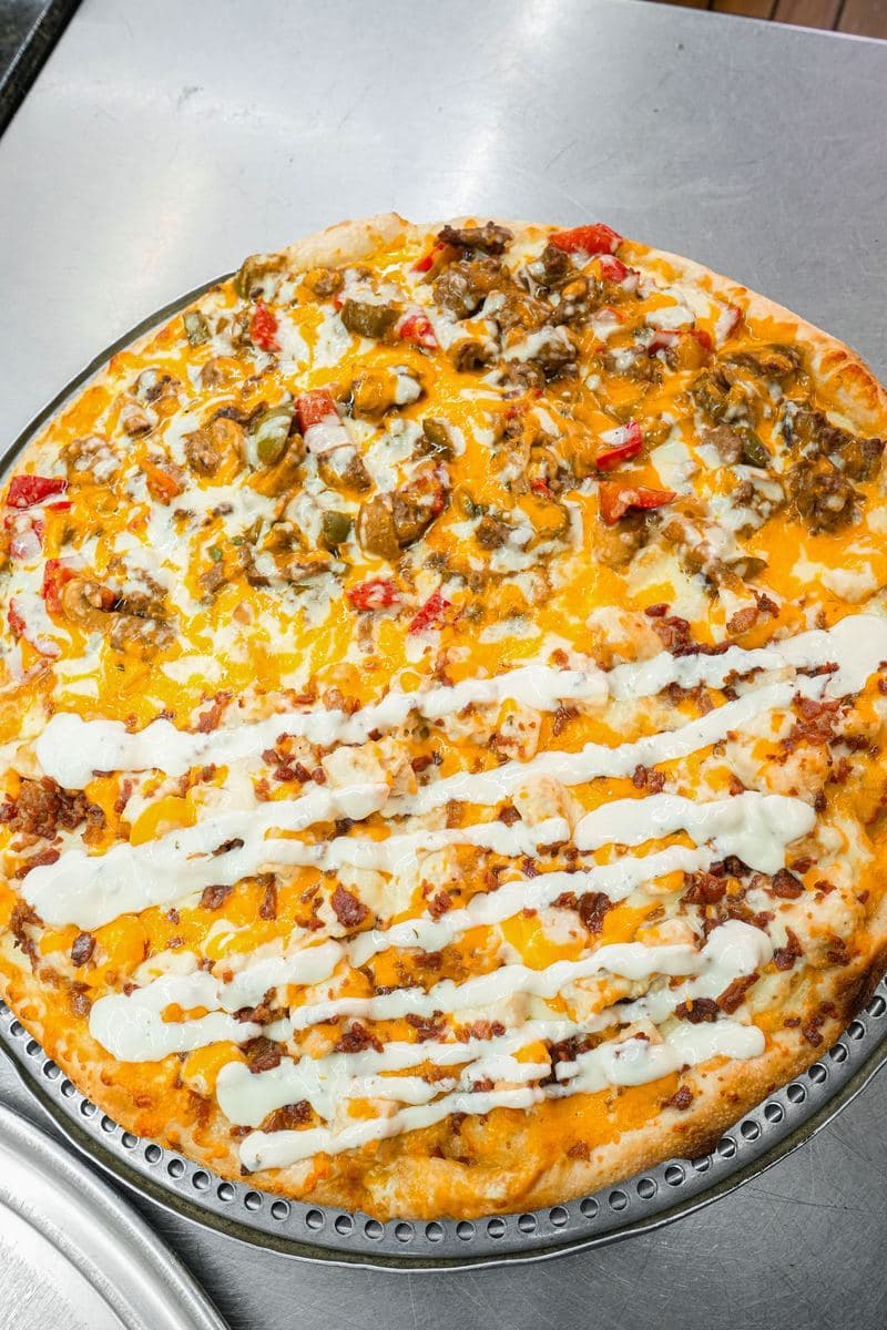 Half-and-half pizza with a cheddar and pepper side and a bacon and ranch drizzle side