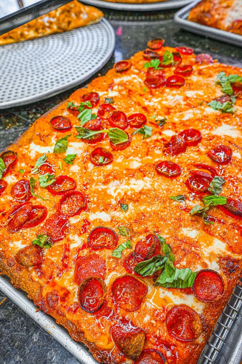 Pepperoni Sicilian with basil, seen from above on the pan