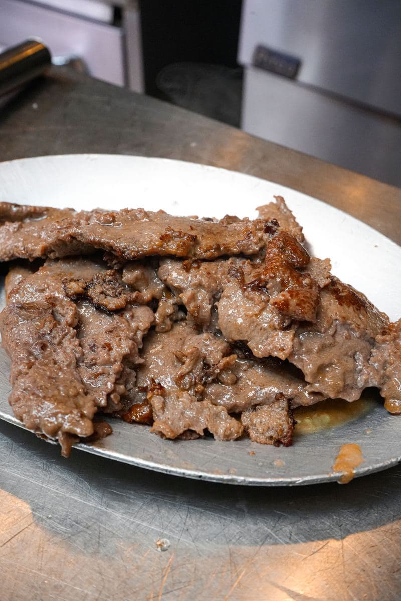 Griddled shaved steak on a pan, ready for a Philly cheesesteak