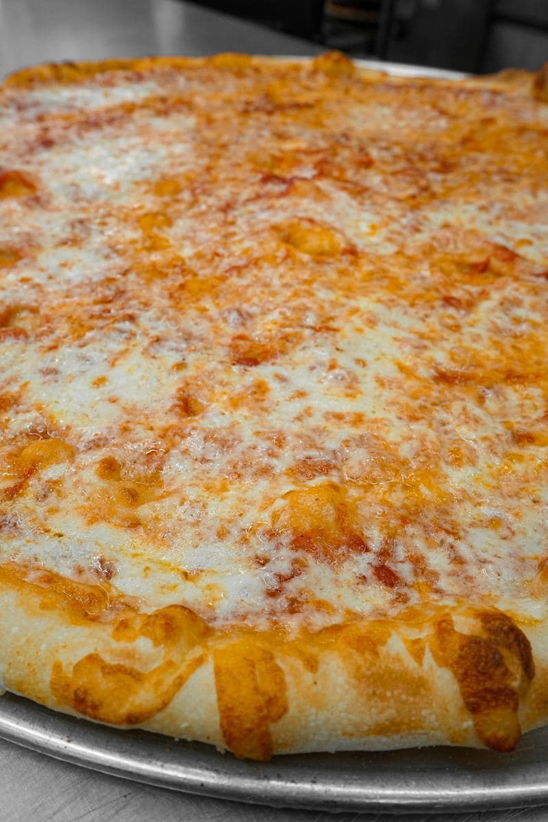 Close-up of a Bonilla's Sicilian pie corner, thick crust under bubbling mozzarella