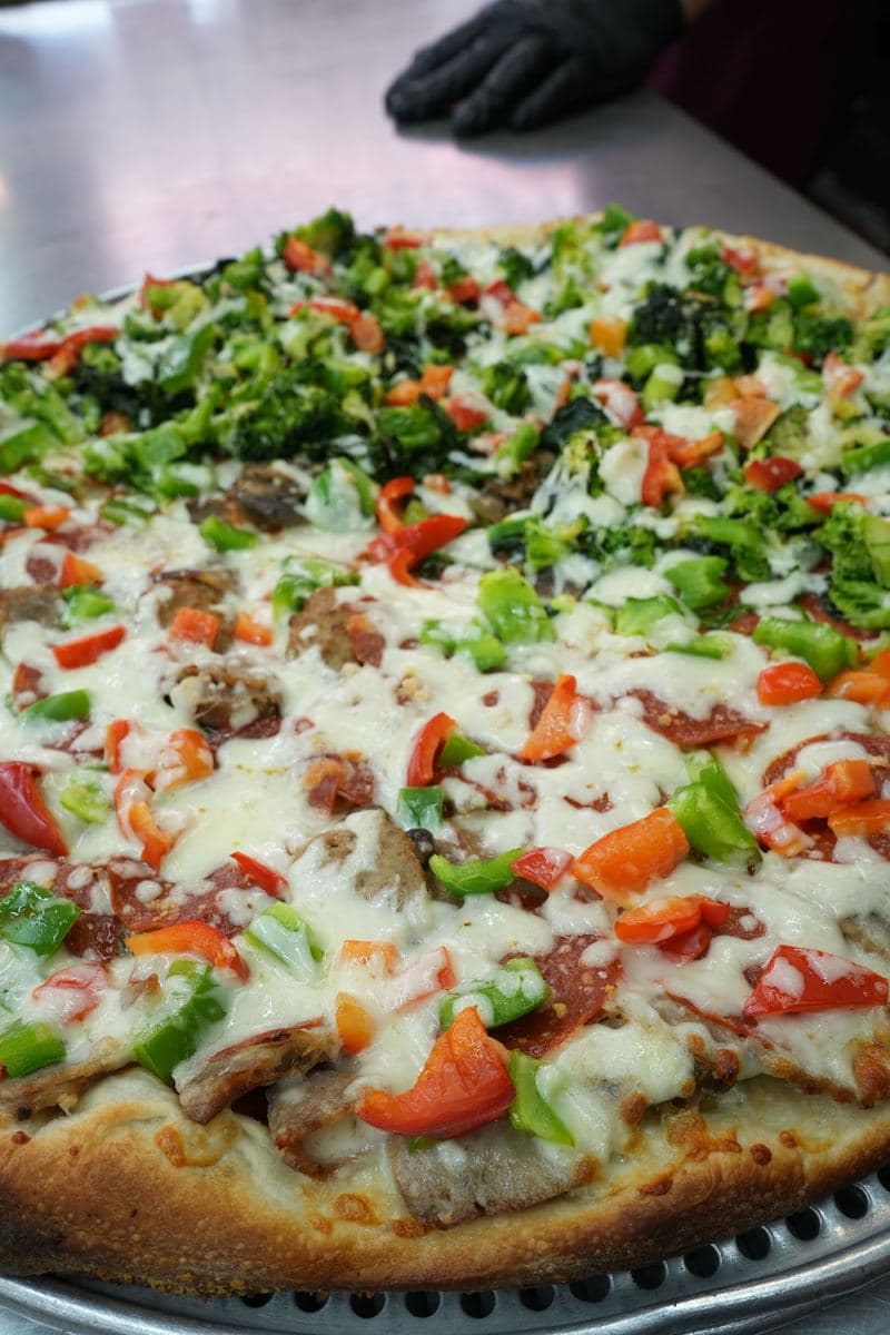 Close-up of a vegetable pie with broccoli, peppers, tomato and mushrooms