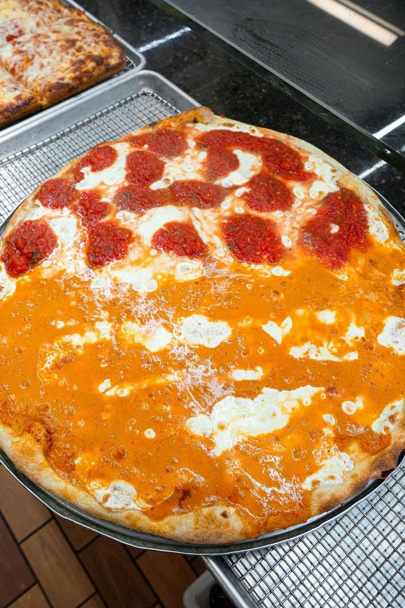 Vodka sauce pie topped with fresh mozzarella and spoonfuls of crushed tomato