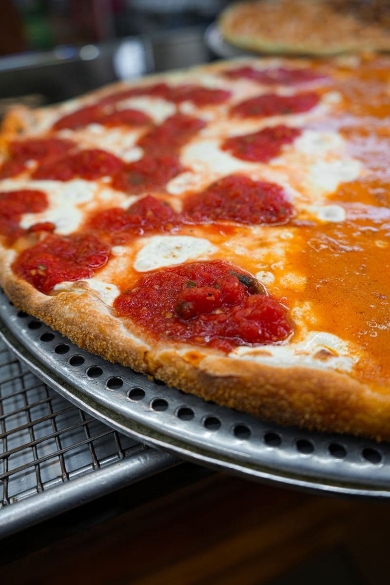 Vodka sauce pie with fresh mozzarella, angled on its pan