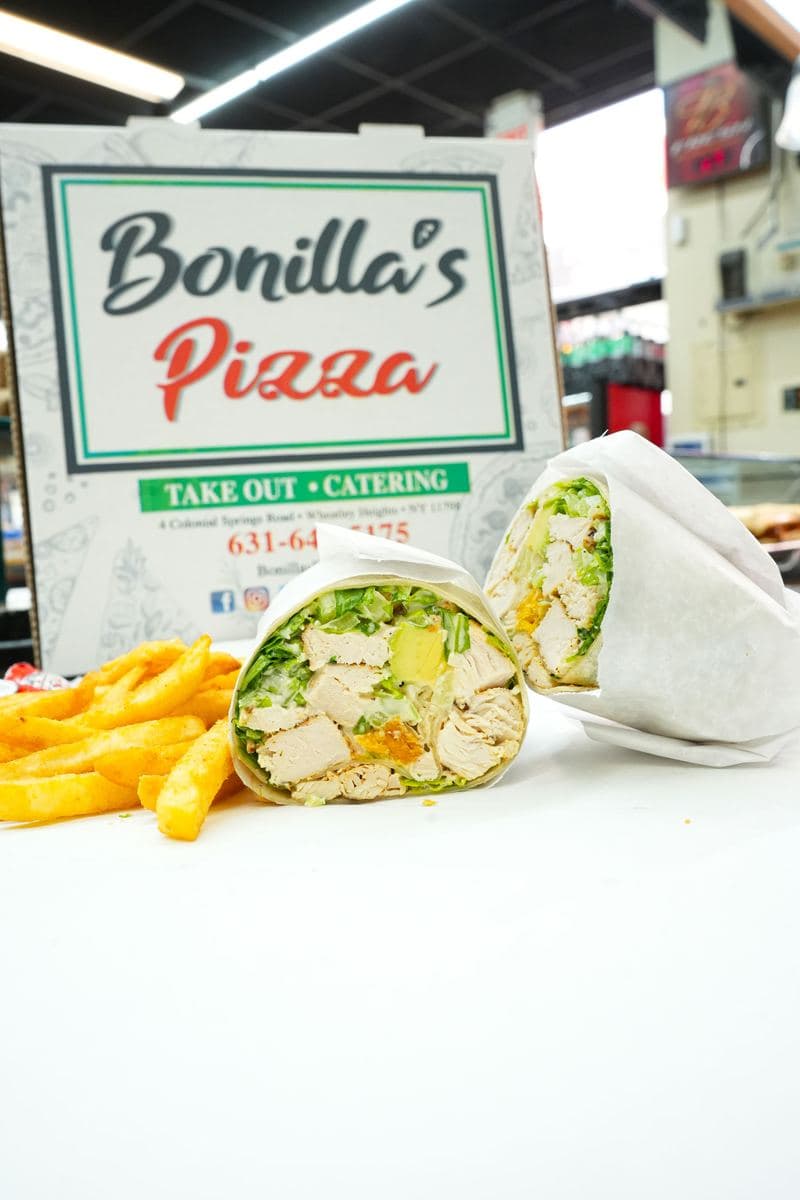 Chicken Caesar wrap and fries in front of a Bonilla's Pizza box